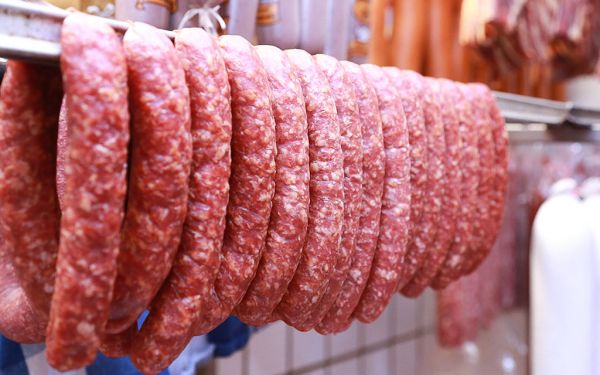 Hängende Wurstwaren im Kühlraum, ordentlich angeordnet und gut sichtbar. 